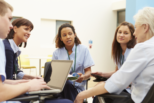 a group of clinicians hold a meeting